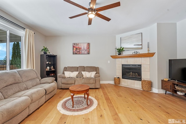 5989 Hidden Highlands Dr, Reno, NV 89502 - living room with hardwood / wood-style floors, a ceiling fan, a tiled fireplace, and baseboards