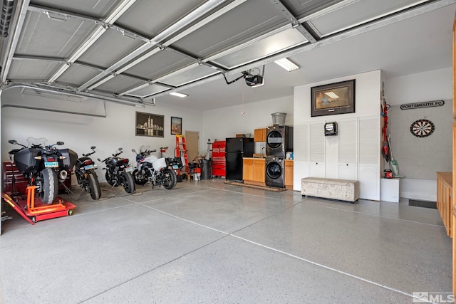 5989 Hidden Highlands Dr, Reno, NV 89502 - garage featuring stacked washing machine and dryer, freestanding refrigerator, and a garage door opener