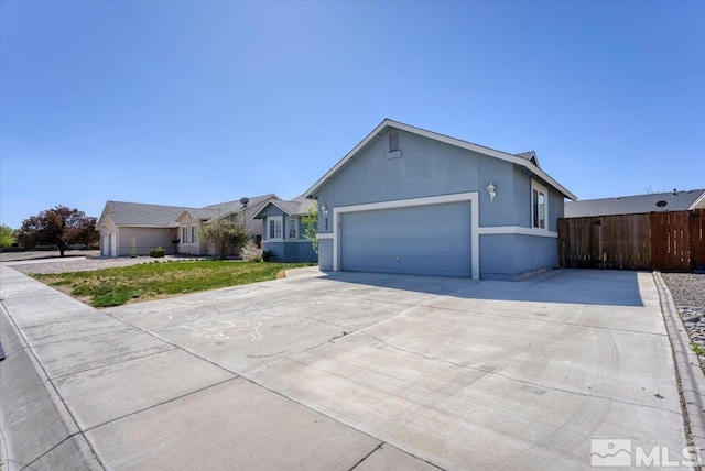 989 Julia Ln, Fernley, NV 89408 - ranch-style home featuring a garage, driveway, and fence