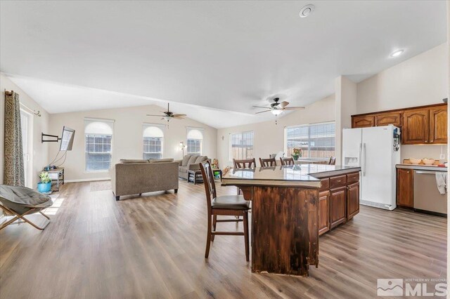 989 Julia Ln, Fernley, NV 89408 - kitchen featuring white refrigerator with ice dispenser, dishwasher, vaulted ceiling, a kitchen breakfast bar, and a ceiling fan