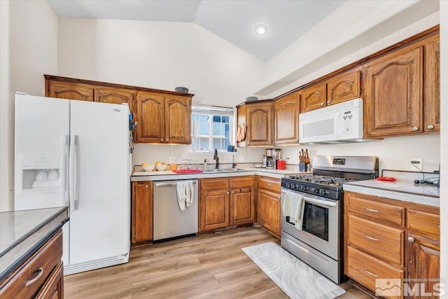 989 Julia Ln, Fernley, NV 89408 - kitchen featuring appliances with stainless steel finishes, a sink, brown cabinets, light countertops, and light wood-style floors