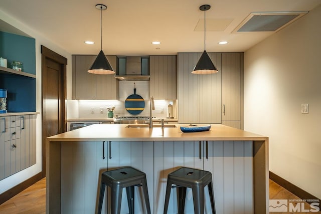 17 Beach Club Dr Unit 221, Stateline, NV 89449 - kitchen featuring light wood-style floors, light countertops, a sink, wall chimney range hood, and decorative backsplash