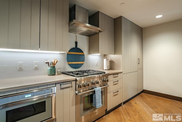 17 Beach Club Dr Unit 221, Stateline, NV 89449 - kitchen with appliances with stainless steel finishes, wall chimney exhaust hood, light countertops, light wood-type flooring, and baseboards