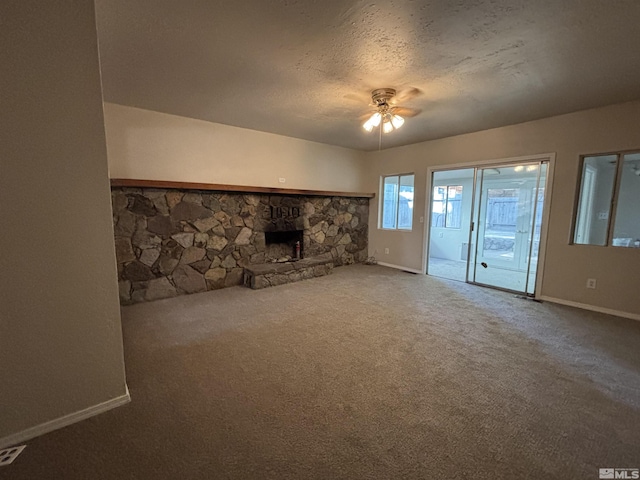 2602 William Ave, South Lake Tahoe, CA 96150 - unfurnished living room featuring carpet floors, a stone fireplace, ceiling fan, baseboards, and a textured ceiling