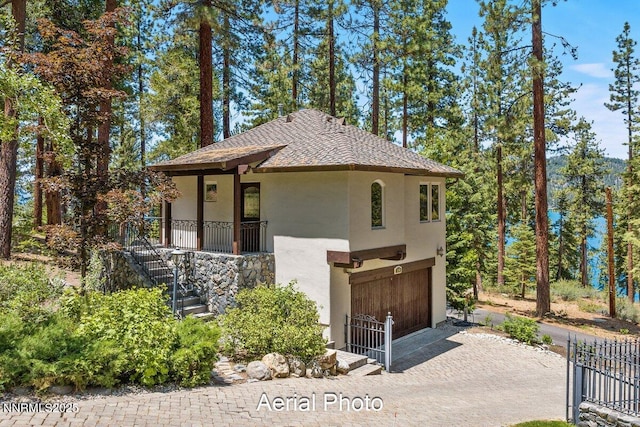 190 Yellow Jacket, Glenbrook, NV 89413 - view of front of house with stucco siding, a garage, driveway, stairway, and roof with shingles