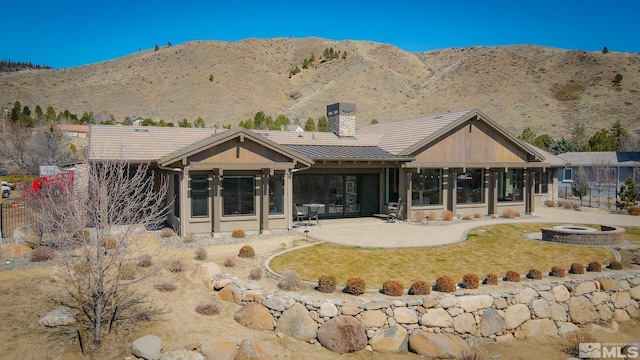 46 Silver Lynx Way, Verdi, NV 89439 - rear view of property featuring an outdoor fire pit, a standing seam roof, a patio area, a chimney, and metal roof