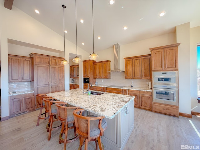 46 Silver Lynx Way, Verdi, NV 89439 - kitchen featuring wall chimney range hood, a sink, brown cabinetry, black electric cooktop, and decorative backsplash