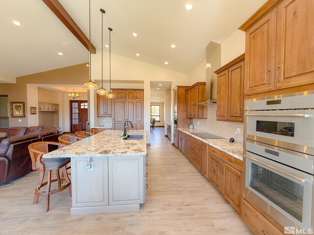 46 Silver Lynx Way, Verdi, NV 89439 - kitchen with double oven, open floor plan, black electric cooktop, light stone counters, and a breakfast bar area