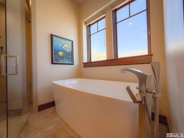 46 Silver Lynx Way, Verdi, NV 89439 - full bathroom featuring a soaking tub, a stall shower, and baseboards