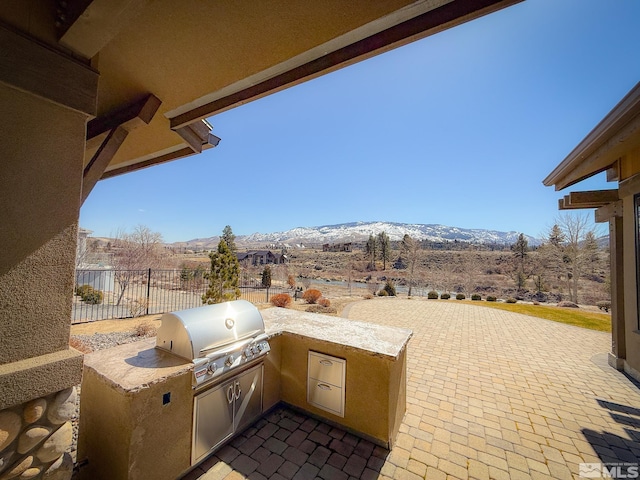 46 Silver Lynx Way, Verdi, NV 89439 - view of patio / terrace featuring a mountain view, grilling area, fence, and an outdoor kitchen