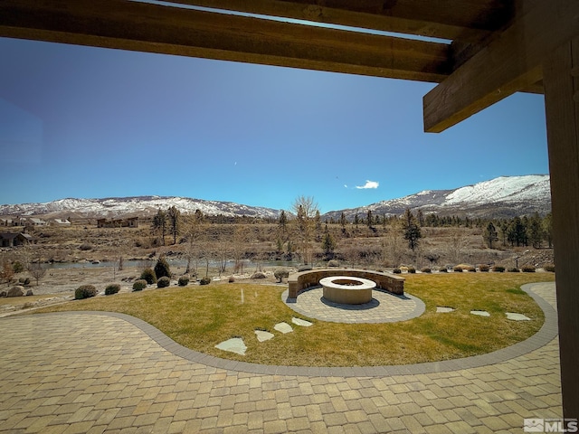 46 Silver Lynx Way, Verdi, NV 89439 - view of green lawn with a mountain view, a fire pit, and a patio area