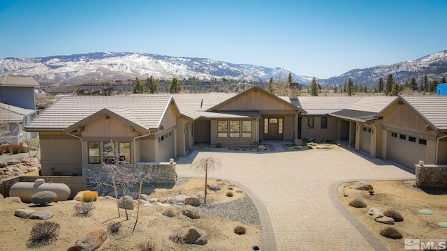 46 Silver Lynx Way, Verdi, NV 89439 - view of front of house featuring an attached garage, decorative driveway, a mountain view, and a chimney
