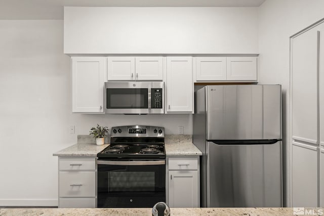 6850 Sharlands Ave Unit Y1149, Reno, NV 89523 - kitchen featuring stainless steel appliances, light stone counters, white cabinets, and baseboards