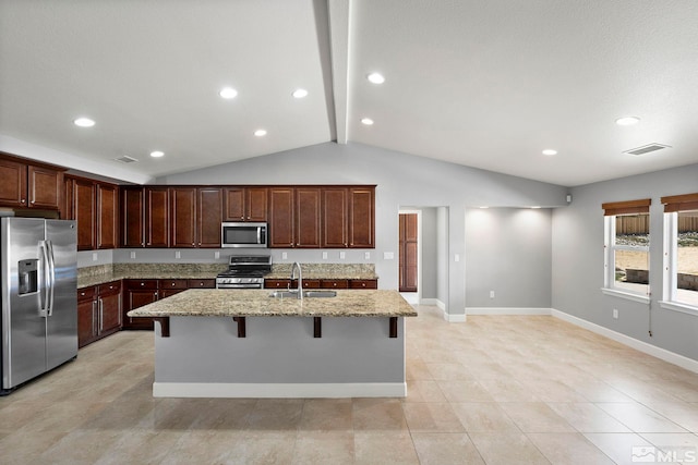 7760 Sonic Ct, Sparks, NV 89436 - kitchen with appliances with stainless steel finishes, a sink, a kitchen bar, light stone countertops, and a center island with sink