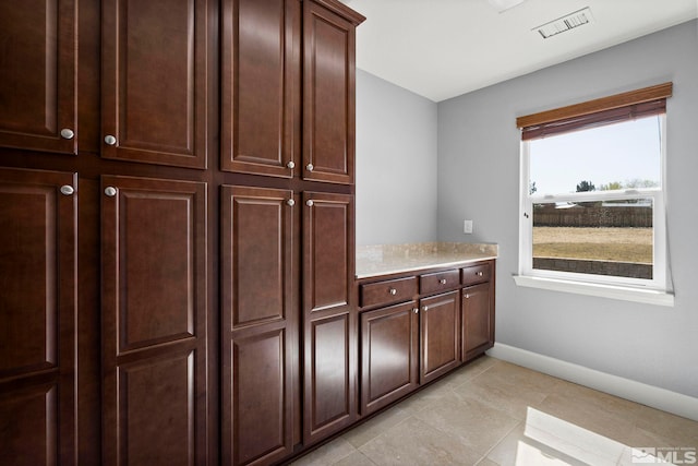 7760 Sonic Ct, Sparks, NV 89436 - kitchen featuring light countertops, baseboards, light tile patterned floors, and dark brown cabinetry