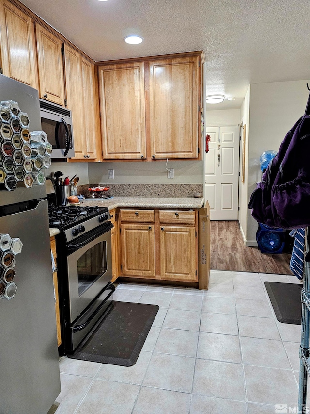 900 S Meadows Pkwy Unit 5414, Reno, NV 89521 - kitchen with stainless steel appliances, light countertops, light tile patterned flooring, a textured ceiling, and recessed lighting