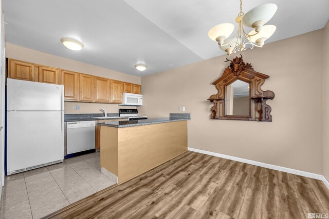 3089 Cashill Blvd, Reno, NV 89509 - kitchen featuring white appliances, a chandelier, a peninsula, baseboards, and a sink