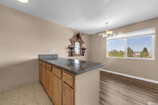 3089 Cashill Blvd, Reno, NV 89509 - kitchen with a peninsula, baseboards, a chandelier, and dark stone counters