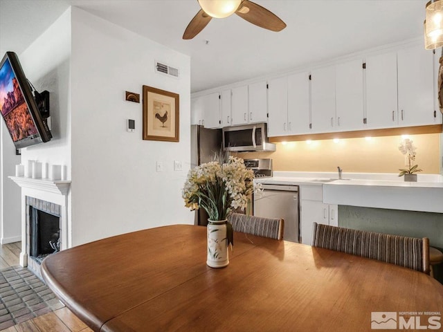 555 Tahoe Keys Blvd Unit 14, South Lake Tahoe, CA 96150 - dining space with a ceiling fan, light wood finished floors, and a fireplace