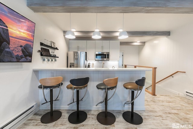 989 Tahoe Blvd Unit 36, Incline Village, NV 89451 - kitchen with stainless steel appliances, a baseboard heating unit, light wood-style floors, a kitchen breakfast bar, and baseboards
