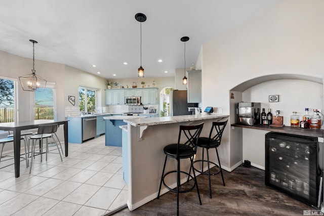 2900 Ariel Dr, Reno, NV 89523 - kitchen with beverage cooler, stainless steel appliances, a peninsula, blue cabinets, and a kitchen breakfast bar