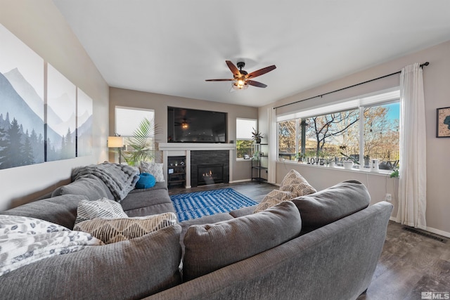 2900 Ariel Dr, Reno, NV 89523 - living room featuring dark wood-style flooring, a ceiling fan, baseboards, and a glass covered fireplace