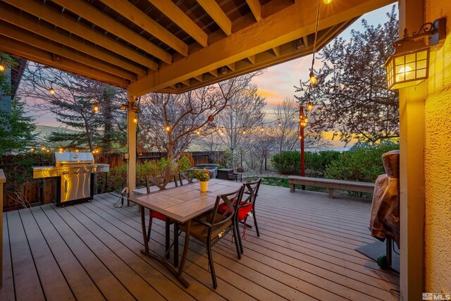 2900 Ariel Dr, Reno, NV 89523 - deck at dusk featuring a fenced backyard, area for grilling, and outdoor dining space