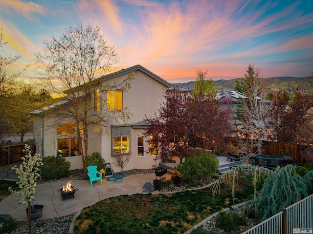 2900 Ariel Dr, Reno, NV 89523 - rear view of house with an outdoor fire pit, a patio area, a fenced backyard, stucco siding, and a jacuzzi