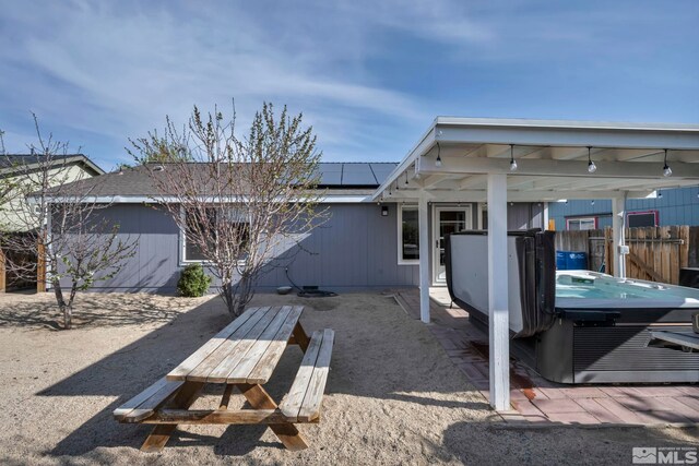 233 Jennys Ln, Fernley, NV 89408 - rear view of house with solar panels, fence, and a hot tub