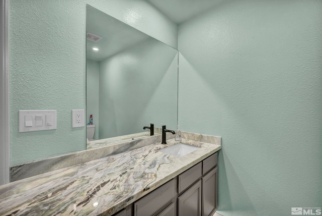 233 Jennys Ln, Fernley, NV 89408 - bathroom with a textured wall, vanity, and toilet