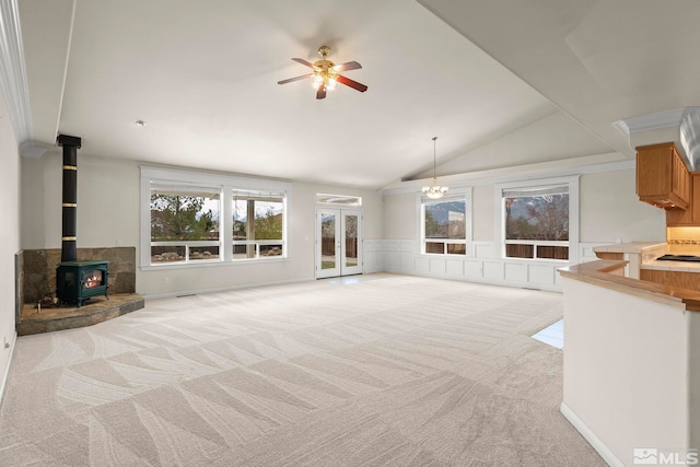 1147 Country Club Dr, Minden, NV 89423 - unfurnished living room with light colored carpet, a wood stove, ceiling fan, lofted ceiling, and wainscoting