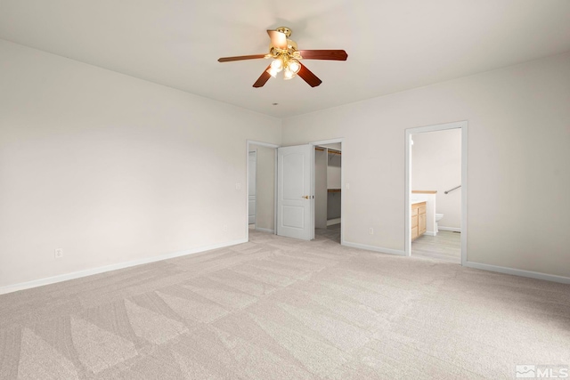 1147 Country Club Dr, Minden, NV 89423 - unfurnished bedroom with light colored carpet, baseboards, connected bathroom, and a walk in closet