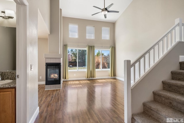 503 Windchase Dr, Dayton, NV 89403 - unfurnished living room featuring high vaulted ceiling, ceiling fan, wood finished floors, stairway, and a fireplace