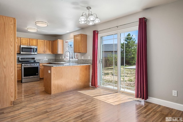 503 Windchase Dr, Dayton, NV 89403 - kitchen featuring stainless steel appliances, a chandelier, light wood-style flooring, a peninsula, and baseboards