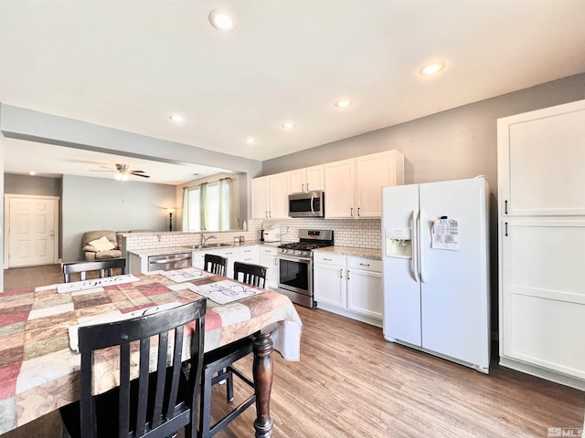1480 Shadow Ln, Fernley, NV 89408 - kitchen featuring appliances with stainless steel finishes, a sink, tasteful backsplash, a ceiling fan, and light wood finished floors
