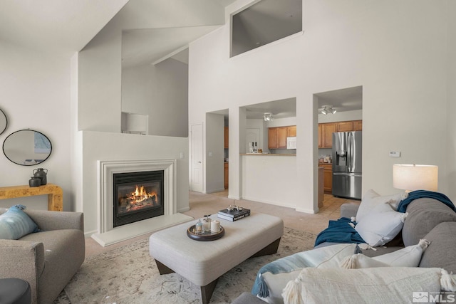 1325 S Meadows Pkwy Unit 322, Reno, NV 89521 - living room featuring a towering ceiling, a glass covered fireplace, light colored carpet, and baseboards