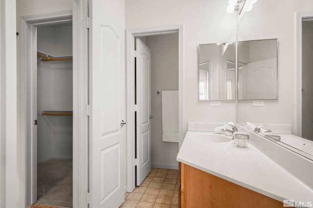 1325 S Meadows Pkwy Unit 322, Reno, NV 89521 - bathroom featuring vanity, a spacious closet, and baseboards