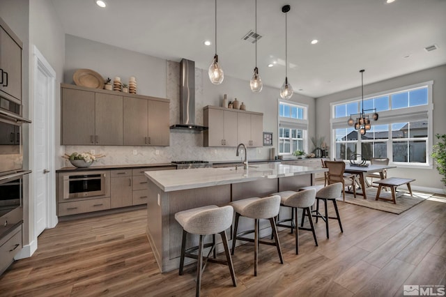 5469 Side Saddle Trl, Reno, NV 89511 - kitchen with wall chimney range hood, a kitchen breakfast bar, wood finished floors, tasteful backsplash, and recessed lighting