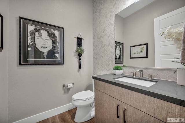 5469 Side Saddle Trl, Reno, NV 89511 - half bathroom featuring vanity, wood finished floors, baseboards, toilet, and decorative backsplash