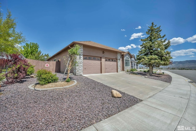 994 Sunview Dr, Carson City, NV 89705 - view of front facade featuring stucco siding, stone siding, a garage, fence, and driveway
