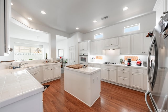 1510 Corleone Dr, Sparks, NV 89434 - kitchen featuring white appliances, tile countertops, white cabinetry, tasteful backsplash, and recessed lighting