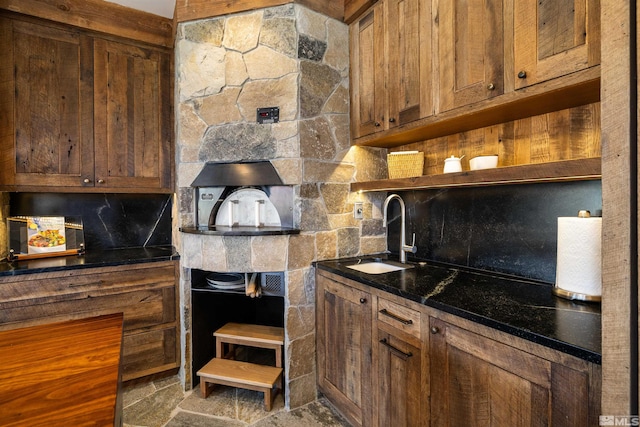 120 W Willis Ln, Reno, NV 89511 - kitchen featuring a sink, open shelves, dark countertops, decorative backsplash, and stone finish floors