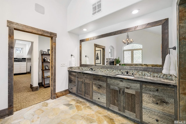 120 W Willis Ln, Reno, NV 89511 - bathroom with a chandelier, stone finish flooring, double vanity, and baseboards