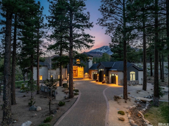 120 W Willis Ln, Reno, NV 89511 - view of front of home with curved driveway, stone siding, board and batten siding, and a mountain view