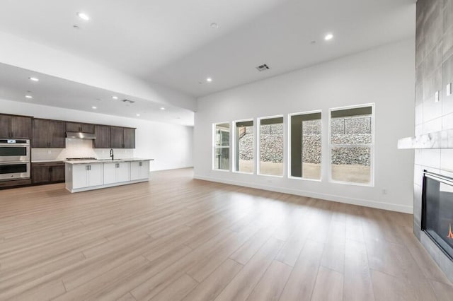 3237 Amaretto Way Unit Cinmon 64, Sparks, NV 89441 - unfurnished living room featuring a sink, a fireplace, light wood-style flooring, recessed lighting, and baseboards