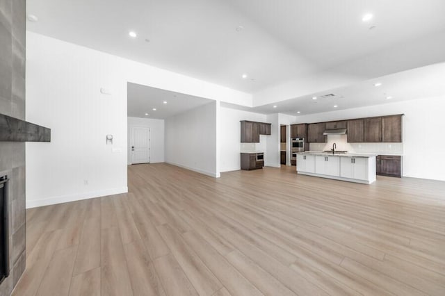 3237 Amaretto Way Unit Cinmon 64, Sparks, NV 89441 - unfurnished living room featuring light wood finished floors, a fireplace, a sink, recessed lighting, and baseboards
