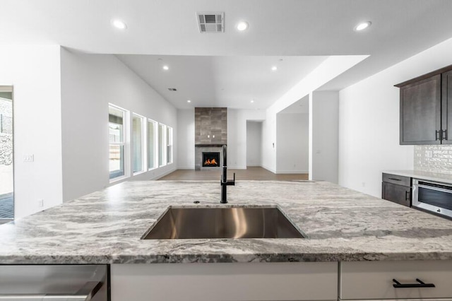 3237 Amaretto Way Unit Cinmon 64, Sparks, NV 89441 - kitchen with a sink, light stone countertops, dishwashing machine, recessed lighting, and a large fireplace