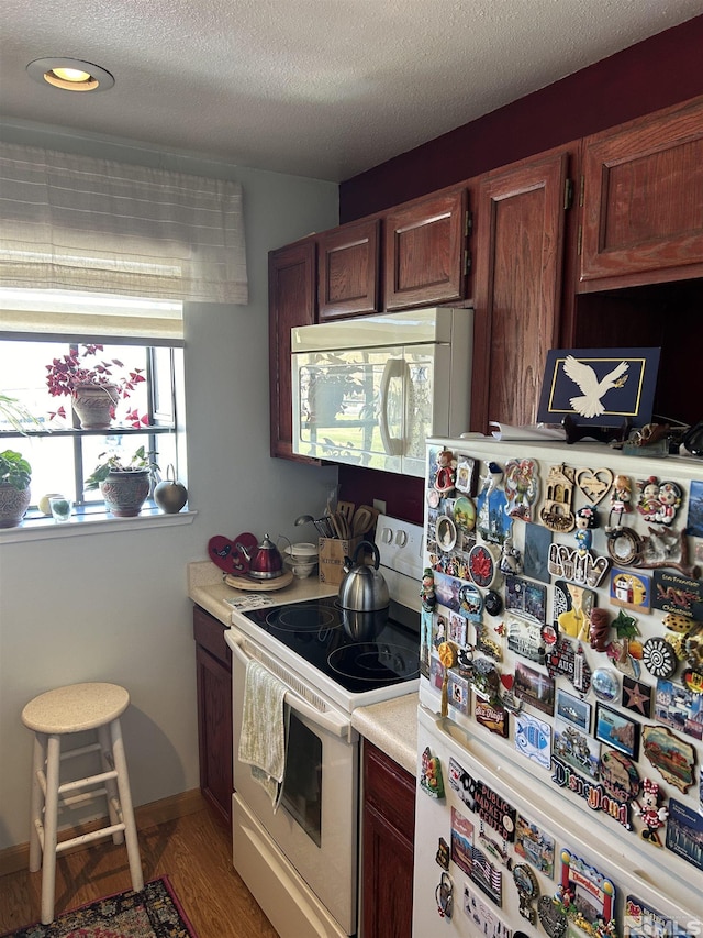 2169 Kietzke Ln Unit E, Reno, NV 89502 - kitchen featuring white appliances, light wood finished floors, light countertops, a textured ceiling, and recessed lighting
