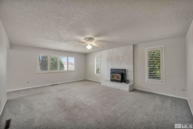 1308 Fremont, Carson City, NV 89701 - unfurnished living room with ceiling fan, carpet, a wood stove, baseboards, and a textured ceiling