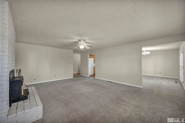 1308 Fremont, Carson City, NV 89701 - unfurnished living room with ceiling fan, carpet flooring, baseboards, a wood stove, and a textured ceiling